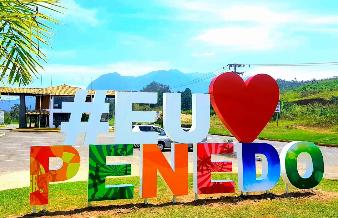Letreiro Eu Amo Penedo com a Serra da Mantiqueira ao fundo